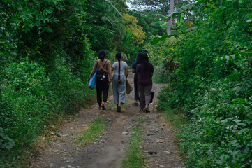 With yoga gear on their backs, the four girls make their way through the tree-lined path, heading...