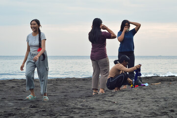 The girls begin organizing their things on the sand, getting ready for a fun morning together at...