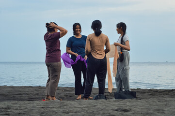 Four girls hold uniquely colored scarves at their sides, readying for their coordinated seaside...