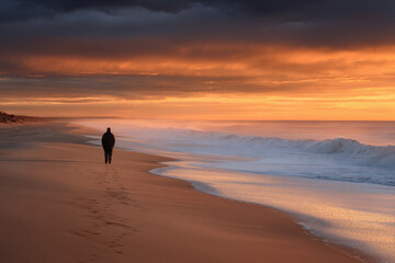 solitary figure stands on deserted beach staring at horizon lost in thoughts of better days