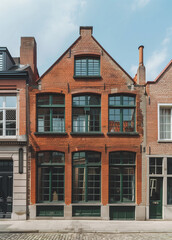 Naklejka premium Charming old townhouse with green doors and red brick walls