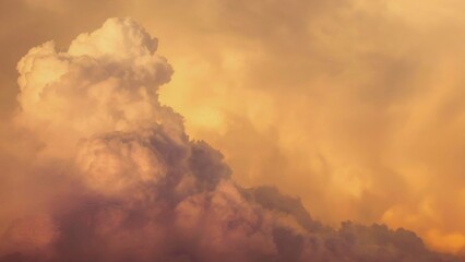 Dramatic golden cloudy sky with sun beam. Yellow sun rays through golden clouds