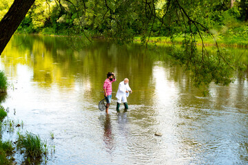 Senior fisherman in suit and bearded casual man fishing with fishing rod.