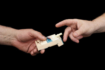 A pack of cigarettes in one hand, while the other holds out fingers to it. Offering and accepting a...