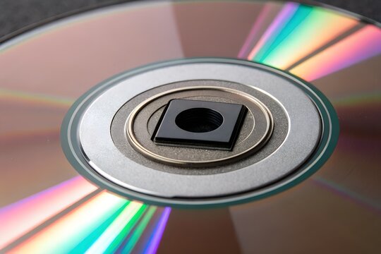 Close up of a cd or dvd disc center with rainbow light reflections