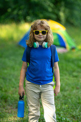 Kid exploring nature outdoors. Child hiking in the forest. Kid on camping. Kid with backpack on a...