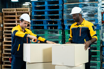 Multiracial warehouse staff team preparing delivery boxes using packing tape during logistics task...