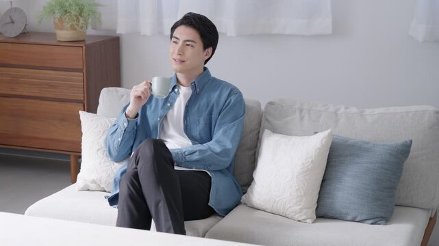 家で飲み物を飲む男性