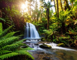 Fototapeta premium Lush waterfall cascading through ferns and ancient forest. Sunlight streams through the canopy