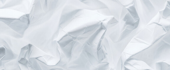 Obraz premium Abstract background of crumpled white paper with soft light and shadow, creating a textured visual that blends minimalism and tactile realism for creative layouts or natural design elements.
