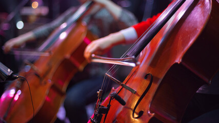 girl playing cello in orchestra on stage