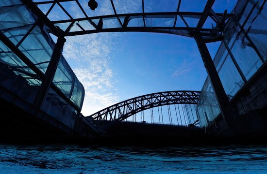 Silhouetted Bridge and Structures Under a Blue Sky