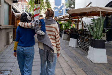 Obraz premium Two friends walking and talking on a city street