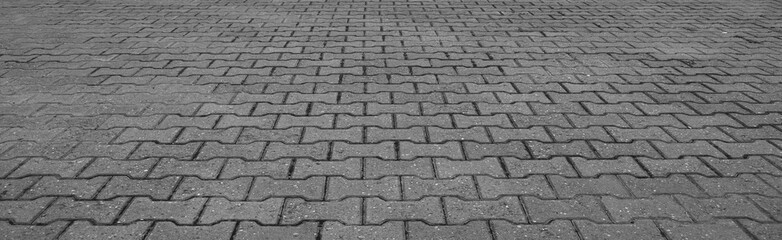 Perspective View Monotone Gray Brick Stone Pavement on The Ground for Street Road. Close - up street cement block tiled paving floor flooring background backdrop.