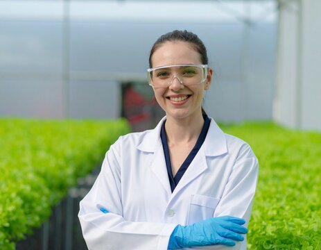 A confident female scientist smiling in a lab coat and safety goggles. A portrait of professionalism in science - Powered by Adobe