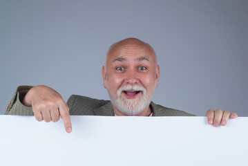 Senior man pointing on empty sign for advertisement. Pensioner pointing at blank board. Elderly man...
