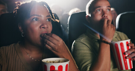 Couple, popcorn and horror movie at theater with snack, date and entertainment at film screening. People, man and woman with shock for thriller in crowd, spooky show or scared with fear at cinema