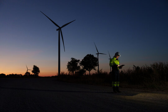 Engineer technician working at wind turbine power plant during sunset Renewable energy solutions for climate change Clean energy - Powered by Adobe