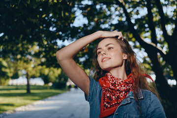 Naklejka premium lifestyle woman in modern boho-western denim street style wearing red bandana outdoors with bright film color sunlight and natural background