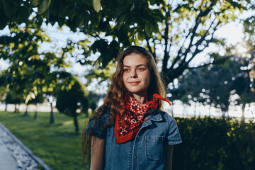 lifestyle woman wearing modern boho-western denim street style outfit with red bandana, standing...