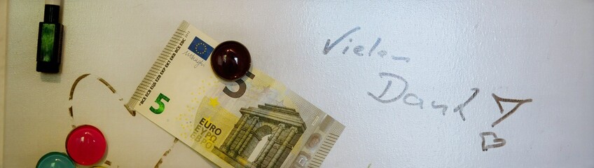 5 Euro Schein an einem whiteboard auf dem "vielen Dank" geschrieben wurde