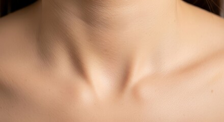 Close-up view of smooth human chest area showing natural skin texture and collarbone definition with soft warm lighting