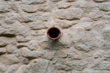 Two roof shingles forming a gargoyle in historic city wall detail