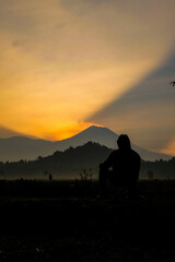 Fototapeta premium Contemplative silhouette at golden mountain sunrise