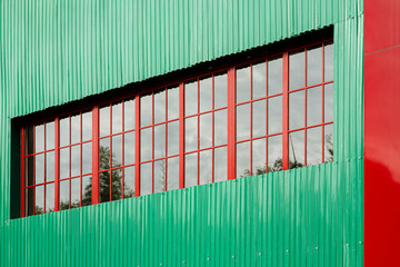 Architectural detail of a modern building with a vibrant green corrugated metal facade and a long...