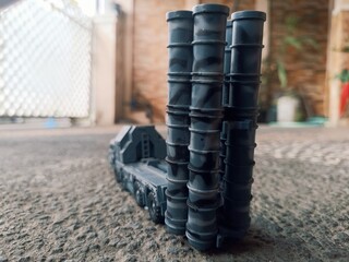 Rear view of a toy missile launcher with four vertical tubes, set on a toy military truck. Captured...