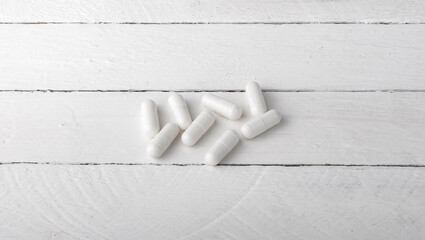 white capsules with medicine on a white background