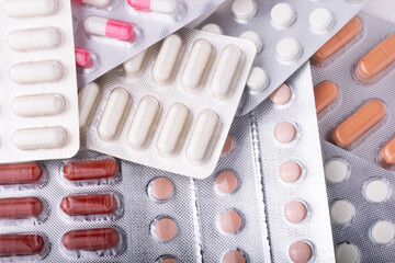 Multi-colored tablets and capsules in blister packaging, pharmaceutical industry concept