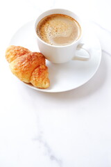 Cup of coffee and croissants
