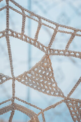 Detailed view of handmade macrame art showcasing intricate knotting techniques indoors during...