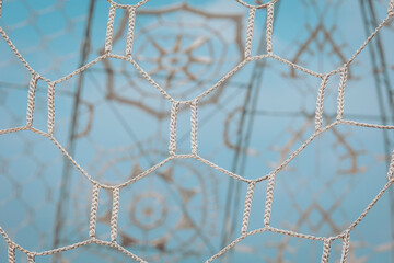 Detailed net structure against a soft blue background highlighting geometric patterns and...