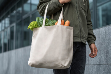 Man carrying groceries in cloth tote bag