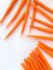 Carrot sticks arranged in a fan pattern on a bright white backdrop, emphasizing their uniformity.