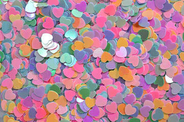Pastel heart shaped confetti background with shimmering holographic sheen
