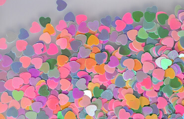 Scattered pastel heart confetti on soft background for heartfelt design projects