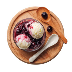 Two scoops of vanilla ice cream topped with cherry compote in a glass bowl on a wooden board