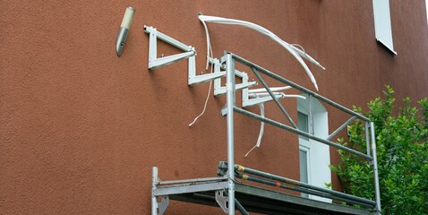 Wall mounts for heat pump on residential facade with scaffold