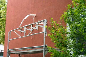 Wall mounts for heat pump on residential facade with scaffold