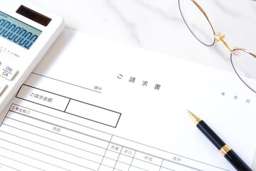 請求書 - 取引先へ宛てて請求書を準備する、ビジネスシーンのイメージ  © PJM