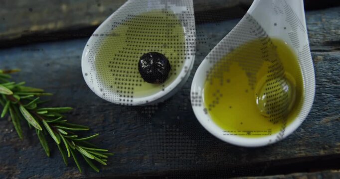 Camera starting close-up on ceramic spoons holding green olive drifting in oil showing rustic style
