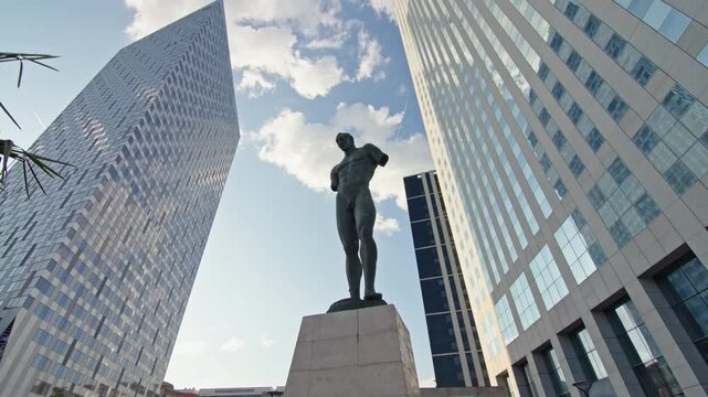 Modern business buildings in the district of La Defense in Paris with glass facades and towers reflecting the sky in the urban cityscape of the capital of France