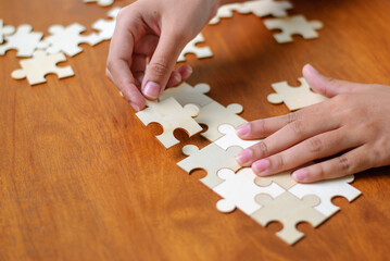 Assembling puzzle pieces home hobby activity cozy environment close-up view mindfulness concept