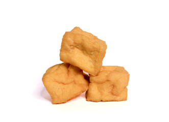 Three golden brown, perfectly fried tofu cubes stacked on a stark white background. Ideal for illustrating Asian cuisine, vegetarian diets, or healthy eating concepts.