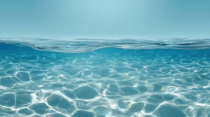 Fototapeta premium A serene view of clear ocean water with gentle waves under a bright blue sky, evoking tranquility and peace.