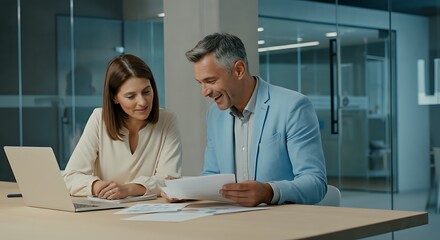 Collaborative business meeting with mature executive and young professional analyzing data and discussing strategy for project success in modern office