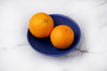 Agrumes oranges dans une assiette bleue
